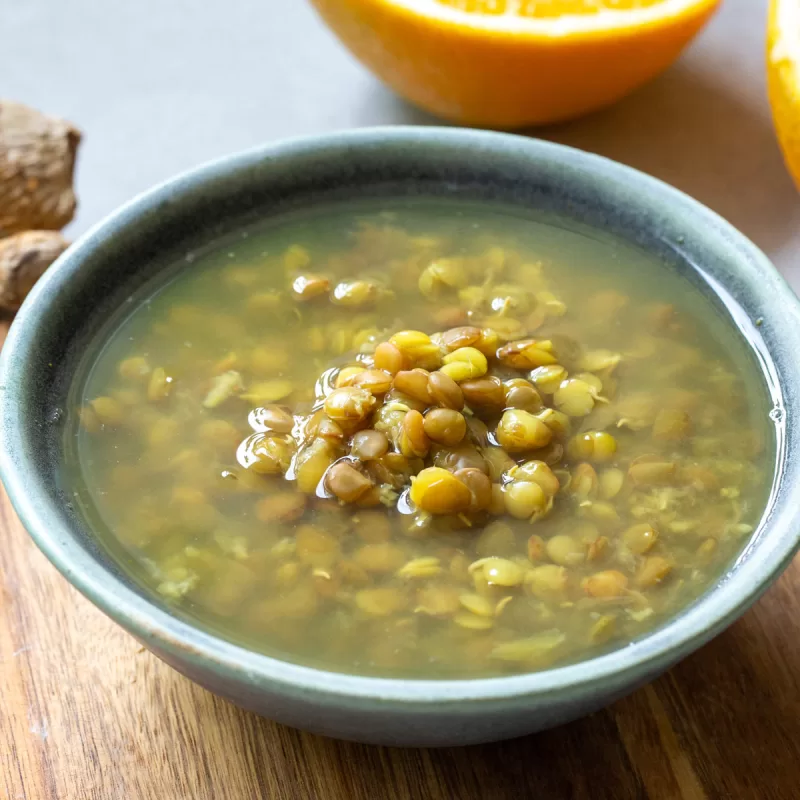 מרק עדשים ירוקות עם ג'ינג'ר ותפוזים בקערת הגשה